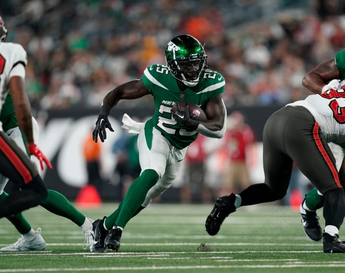 Jets' RB Israel Abanikanda (25) runs through a hole in an NFL Preseason game against the Buccaneers at MetLife Stadium